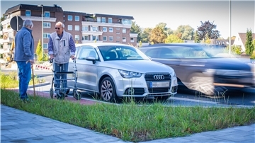 Zwei Männer stehen an der Straße neben geparkten Autos. 