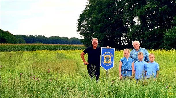 Clubpräsident Norbert Behrends und Landwirt Günter Nagelfeld mit den Enkelkindern auf der Wildblumenwiese in Sievern. 