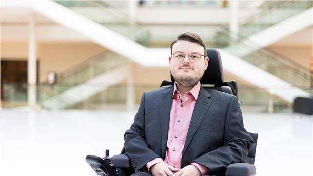 Politiker mit Behinderung vernetzen sich in Hannover Constantin Grosch (SPD), Landtagsabgeordneter in Niedersachsen, sitzt in der Eingangshalle vom Niedersächsischen Landtag.