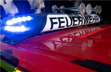 Ein Einsatzfahrzeug der Feuerwehr mit eingeschaltetem Blaulicht.