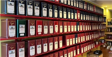 Viele Dosen Tee stehen in einem Regal. 