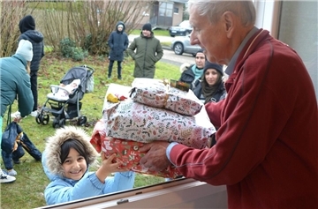 Das wird schwer, auf den Heiligen Abend zu warten: Die siebenjährige Mina strahlt über das ganze Gesicht, als Wolfgang Liedtke ihr die Präsente für sie und ihre Familie in die Arme legt.