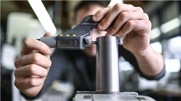zwei Hände umfassen ein Metallwerkstück