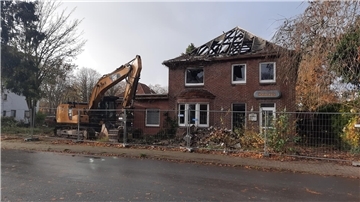 Ein Haus wird mit einem Bagger abgerissen