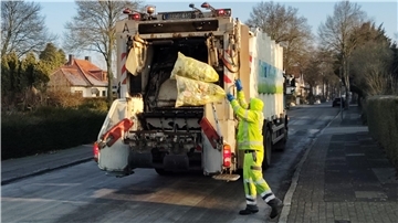 Müllwerker laden Gelbe Säcke auf ihr Fahrzeug.