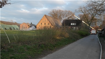 Das Bild zeigt die Einsatzstelle mit dem Bauernhaus in der Mitte, welches von zwei Seiten durch Wassereinsatz gelöscht wird. Rechts unter anderem über das Wenderohr der Drehleiter.