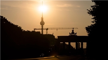 Das Brandenburger Tor und der Fernsehturm sind im Gegenlicht der aufgehenden Sonne zu sehen. Am Montag zeigt sich laut Vorhersage meist die Sonne, höchstens wird es locker bewölkt.