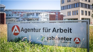 Schild mit Jobcenter-Aufschrift vor Gebäude