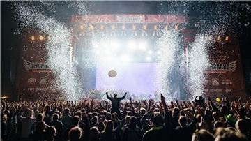 Tausende Festivalbesucher stehen vor einer Bühne auf dem Deichbrand-Festival und jubeln.
