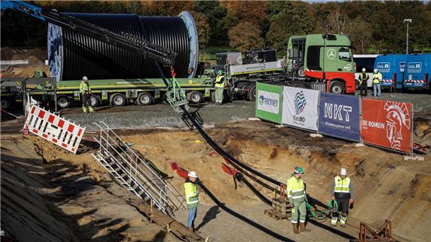 Bau der Trasse Suedlink - Vier Kabel für die Energiewende Das Erdkabel wird mit einem Schwertransporter geliefert und mit Hilfe einer Seilwinde in den Graben gehoben.