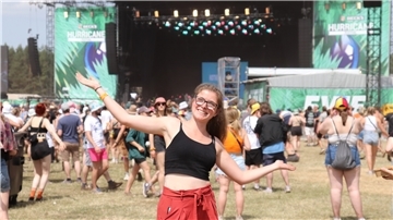 Im Hintergrund ist eine Bühne des Hurricane-Festivals zu sehen. Im Vordergrund ein Mädchen.