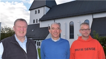 Drei Männer vor einer Kirche