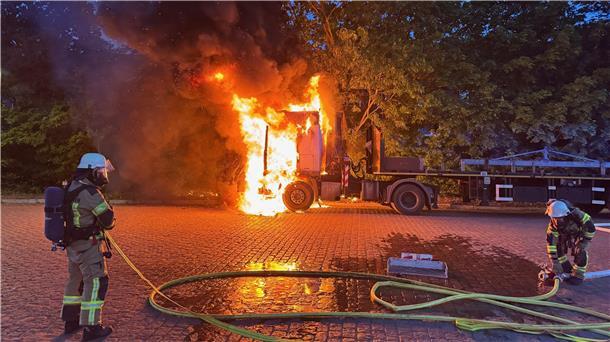 Feuerwehrleute löschen einen brennenden Lkw.