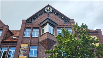 Giebel eines rund 40 Jahren alten Gebäudes mit Glockenspiel.