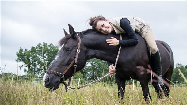 Frau auf Pferd, liegt auf dem Pferderücken