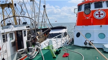 Das havarierte Motorboot wird von einem Fischkutter und dem Seenotrettungskreuzer Hermann Rudolf Meyer gesichert.