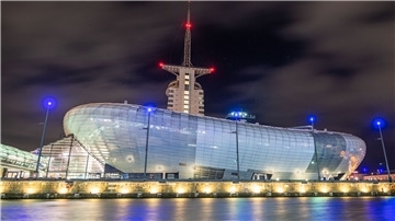 Das beleuchtete Klimahaus-Gebäude  bei Nacht. 