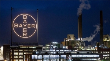 Das Logo des Unternehmens leuchtet auf dem Werksgelände in Leverkusen.