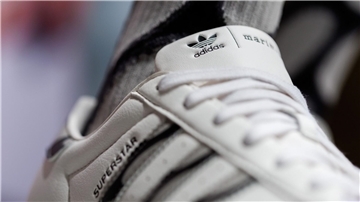 Das Logo und der Schriftzug des Sportartikelherstellers Adidas: Das Unternehmen hat seine neuesten Zahlen vorgelegt.