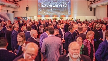 Viele Menschen in einem Saal. 
