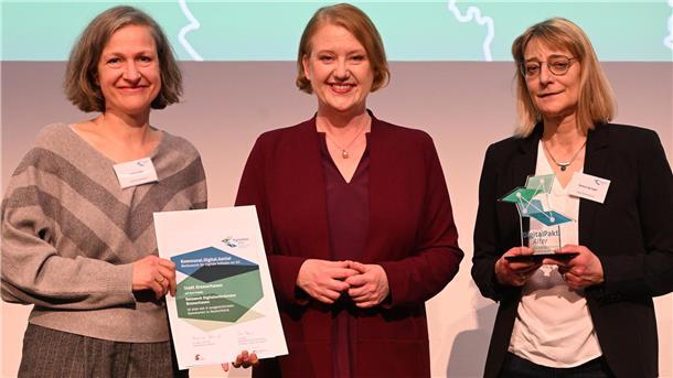 Gruppenfoto mit drei Frauen. Die Frau links hält eine Urkunde in der Hand, die Frau rechts eine Auszeichnung. Das Netzwerk Digitalambulanzen Bremerhaven zählt zu den Gewinnern des bundesweiten Wettbewerbs „Kommunal.Digital.Genial“: Heike Eulitz (links) und Verena Springer (rechts) nahmen die Auszeichnung im Beisein von Bundesseniorenministerin Lisa Paus in Mannheim entgegen.