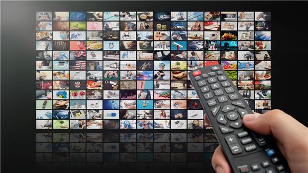 Eine Fernbedienung vor diversen TV-Kacheln.