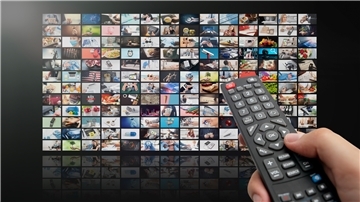 Eine Fernbedienung vor diversen TV-Kacheln.