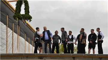 Zimmerleute und Richtkranz auf dem Dach der Haack Tischlerei GmbH