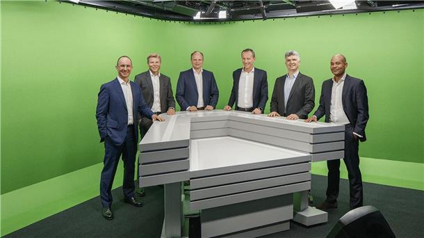Sechs OLB-Manager stehen an einem Tresen.