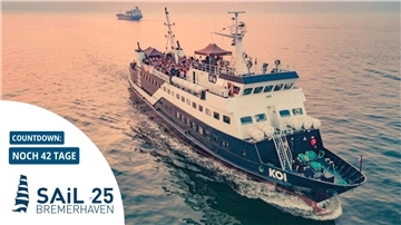 Blick auf ein Schiff mit feiernden Menschen auf See.