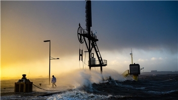  Das „Pressefoto des Jahres“ zeigt einen Spaziergänger, der während einer Sturmflut im Dezember 2023 an der Seebäderkaje in Bremerhaven entlangläuft - nahezu unbeeindruckt von den tosenden Wellen