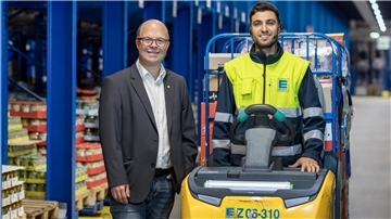 Das Projekt 1+2 zielt auf die Ausbildung von Migranten und hat Erfolg. Bernd Memenga (links) und der Auszubildender Sinasi Ceylan stehen im Edeka-Hochregallager in Neuenkruge an einem Hubwagen.