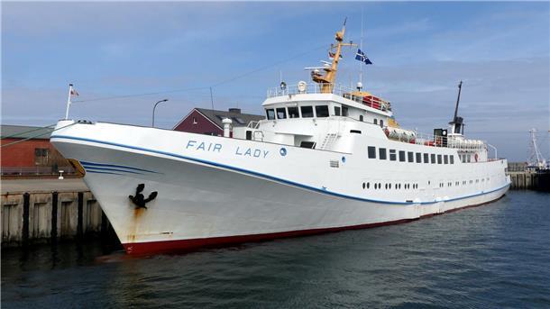Ein weißes Schiff liegt an einer Kaje.