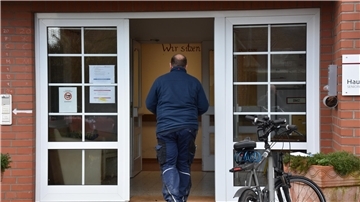 Das Foto zeigt einen Mann, wie er das Pflegeheim Zwei Eichen betritt. 