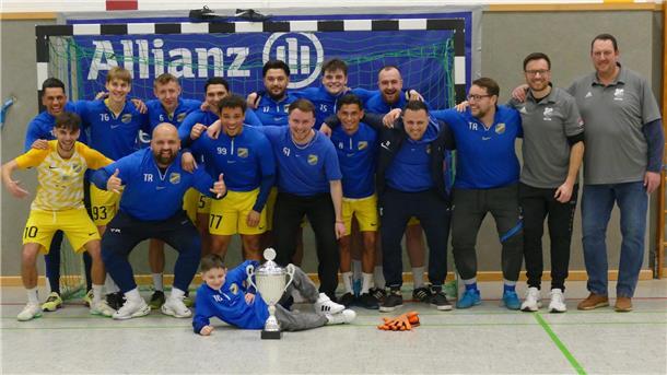 Das Siegerteam TuSpo Surheide mit „Maskottchen“ Ledion Nebihi (liegend, Sohn von Behar Nebihi) sowie den Organisatoren des TSV Stotel Andreas Möller und Frank Jürgens (rechts).