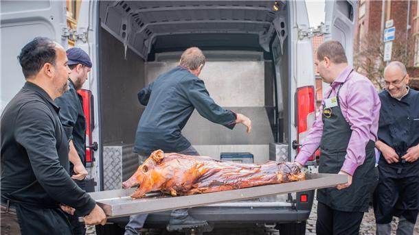 Ein Herz für 400 Bedürftige beim Oster-Festmahl in Bremerhaven Das Spanferkel darf nicht fehlen. Alexis Vaiou packt beim Ausladen des kulinarischen Highlights mit an.