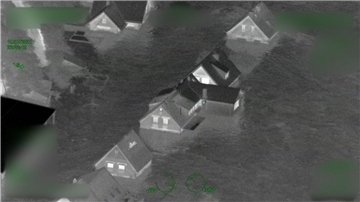 Das Standbild aus einem der Polizeivideos zeigt Häuser im Ahrtal, die bereits vom Wasser eingeschlossen sind.