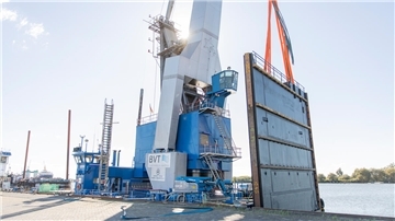 Das gigantische Sperrwerk steht bereit für den Transport – aufgerichtet auf dem Kran „Athlet“ an der Kaje im Fischereihafen.