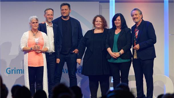Das Team von „Im Takt: Wege in den Jugendhof Turgau“ steht bei der Verleihung des Grimme Online Award 2023 mit dem Preis in der Kategorie „Wissen und Bildung“ auf der Bühne.