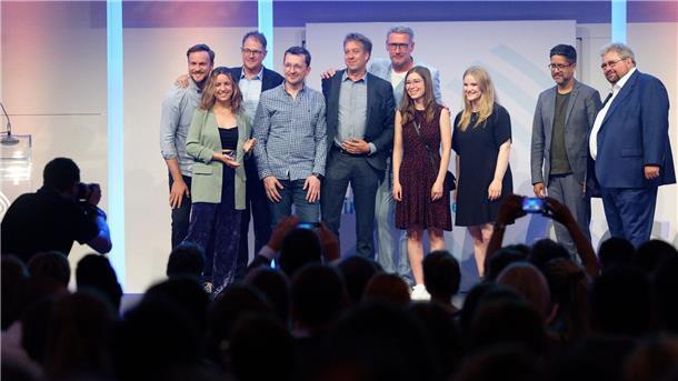 Das Team von „Stolpersteine NRW“ steht bei der Verleihung des Grimme Online Award 2023 mit dem Preis in der Kategorie „Wissen und Bildung“ auf der Bühne.