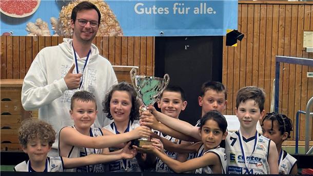 Junge Basketballer freuen sich mit ihrem Trainer über einen Turniersieg.  