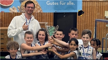 Junge Basketballer freuen sich mit ihrem Trainer über einen Turniersieg.  