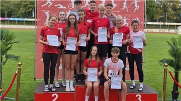 Das U18-Mixed-Team des TV Loxstedt steht und sitzt auf dem Siegertreppchen und zeigt seine Urkunden in die Kamera.