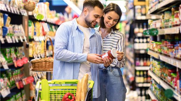 Die Wahrheit hinter den Claims: Verständnis von Werbeaussagen auf Verpackungen Ein junges Paar im Supermarkt schaut sich eine Soße an.