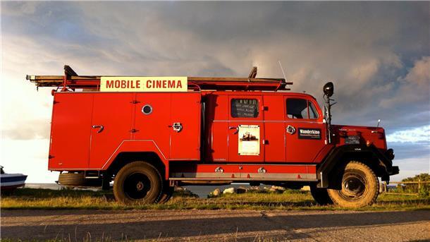 Ein rotes Feuerwehrauto auf dem "Wanderkino" steht.
