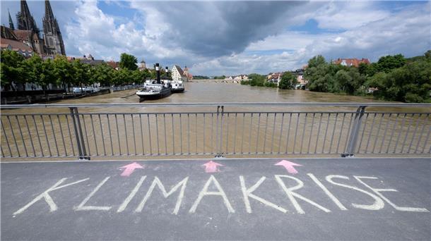 Bange Stunden an der Donau - Weitere Tote in Bayern entdeckt Das Wort „Klimakrise“ ist auf einer Brücke über der Donau in Regensburg zu lesen.