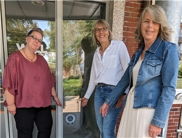 Betriebsrätin Claudia Bathke, Geschäftsführerin Regina Neuke sowie die Administrative Leiterin Gabriele Jahn zeigen auf das neue Siegel