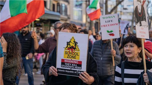 Demonstranten protestieren in Barcelona mit Plakaten und Fahnen gegen eine mutmaßliche Vergiftungswelle in Schulen in Iran.