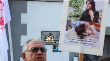 Ein Mann protestiert vor einer Botschaft.