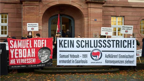 Prozess 31 Jahre nach Anschlag auf Asylbewerberheim Demonstranten stehen vor dem Prozessbeginn am Eingang des Oberlandesgerichts.